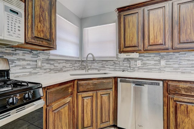 kitchen featuring tile patterned flooring, sink, stainless steel appliances, and tasteful backsplash