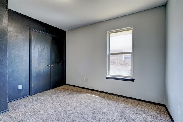 unfurnished bedroom featuring light carpet and a closet