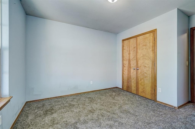 unfurnished bedroom featuring carpet and a closet