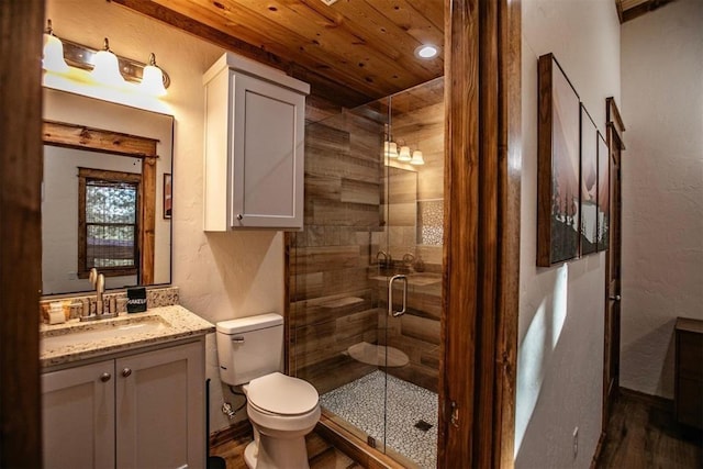 bathroom with hardwood / wood-style flooring, vanity, toilet, and a shower with door