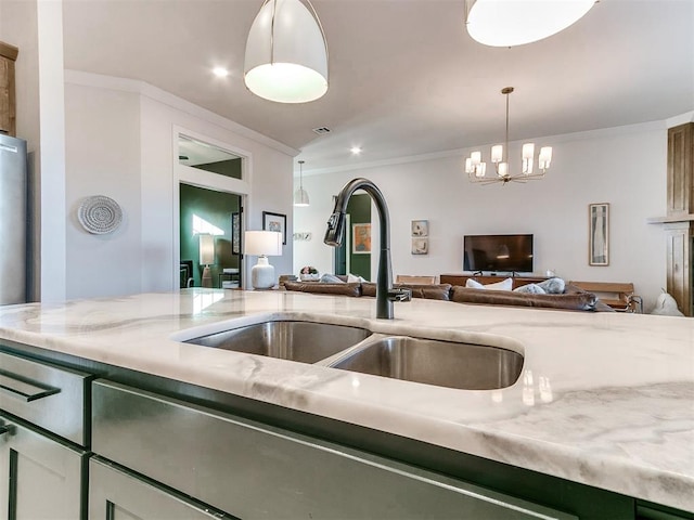 kitchen with ornamental molding, sink, hanging light fixtures, and a notable chandelier