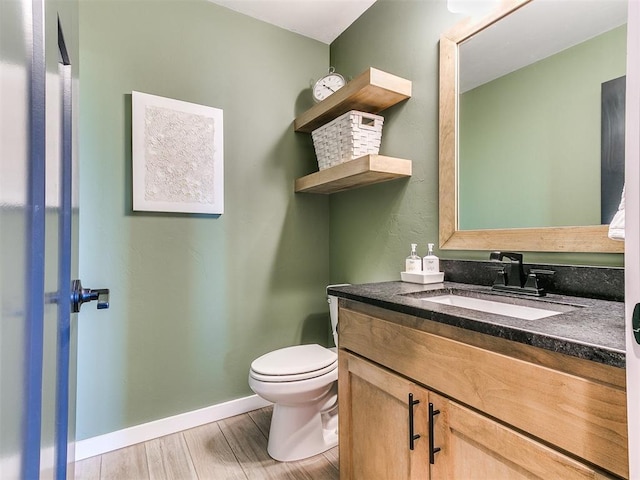 bathroom featuring vanity, hardwood / wood-style floors, and toilet