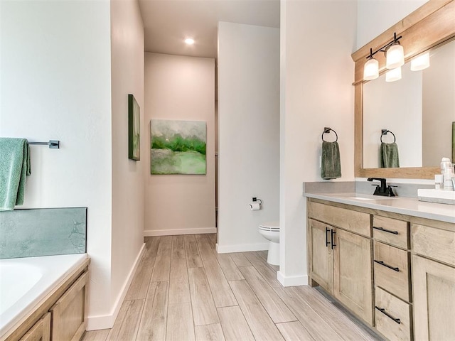 bathroom with vanity, hardwood / wood-style floors, a bath, and toilet