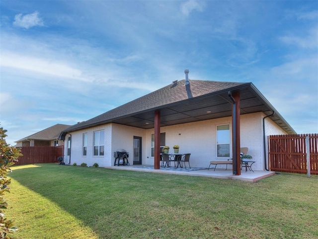 back of house featuring a patio area and a lawn