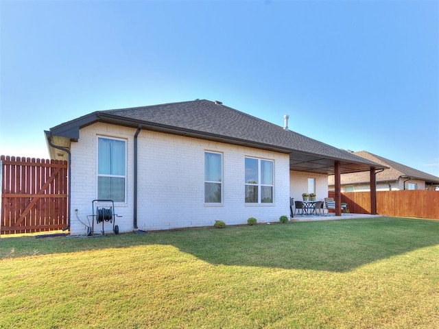 back of house with a patio and a yard