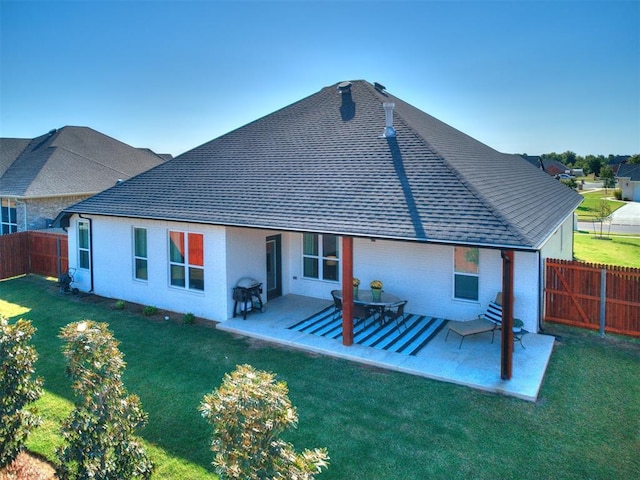 rear view of property with a lawn and a patio area