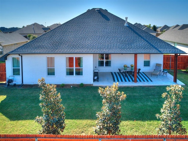 rear view of house with a patio area and a lawn