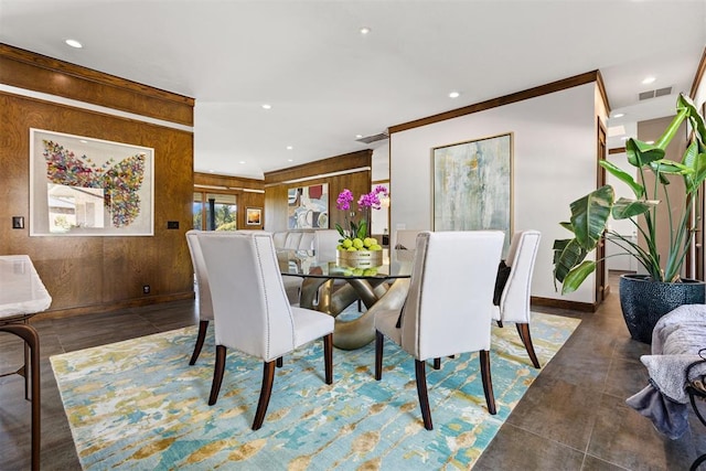 dining area with wooden walls and ornamental molding