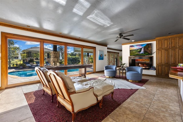 living room with tile patterned floors, ceiling fan, and crown molding