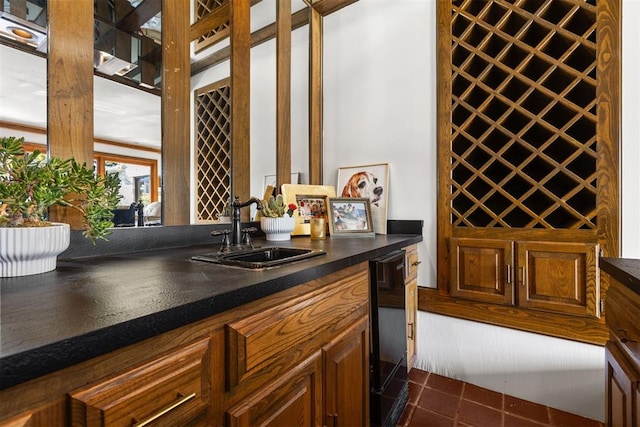 wine room featuring dark tile patterned floors and indoor wet bar