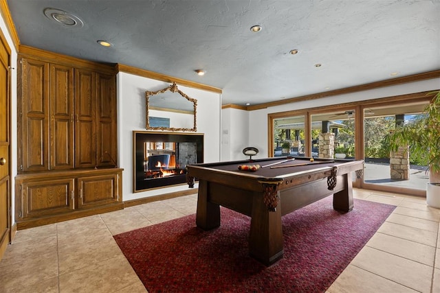 rec room featuring a multi sided fireplace, billiards, crown molding, a textured ceiling, and light tile patterned floors