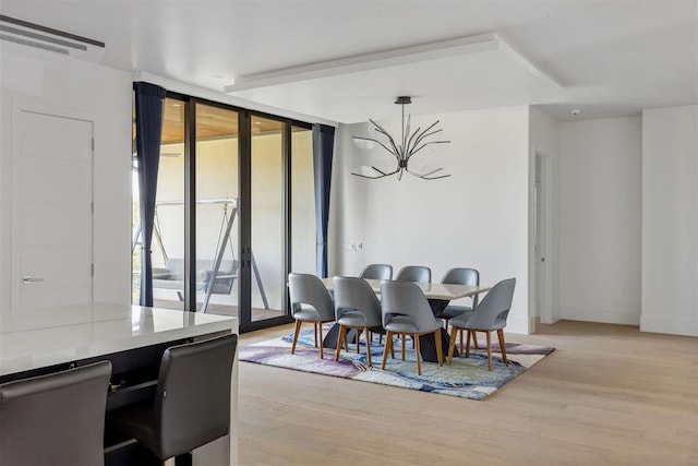 dining area with expansive windows and light wood-type flooring