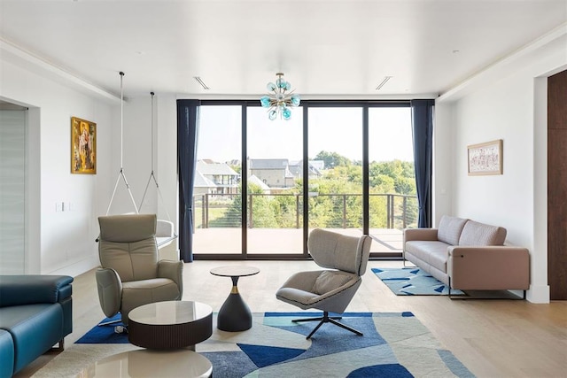 living room featuring light hardwood / wood-style flooring, a wall of windows, and a notable chandelier