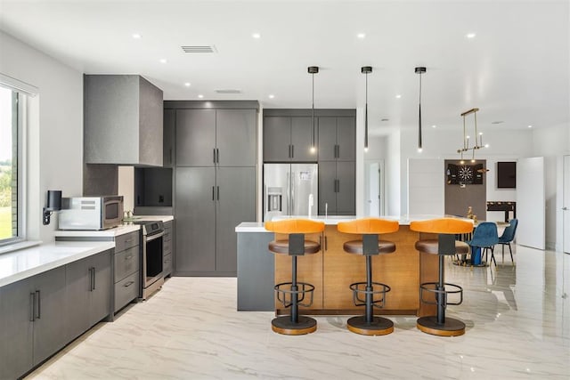 kitchen featuring stainless steel appliances, plenty of natural light, and a breakfast bar area