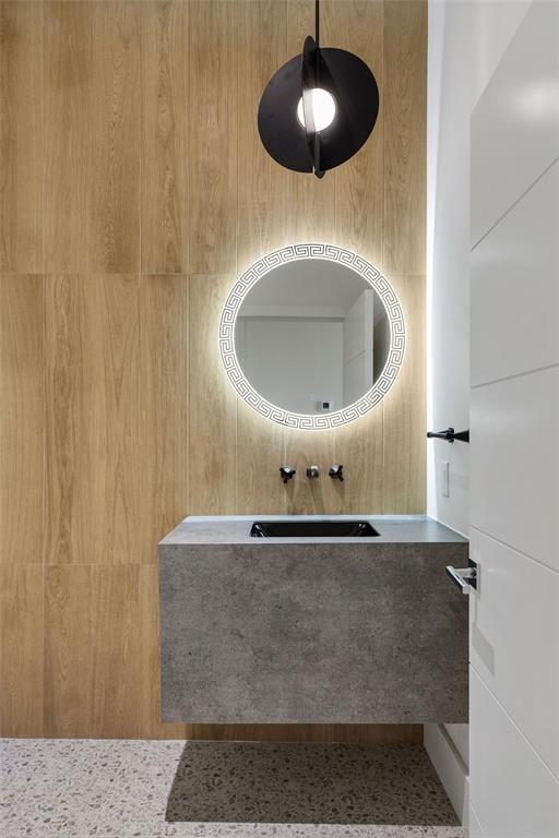 bathroom with sink and wooden walls