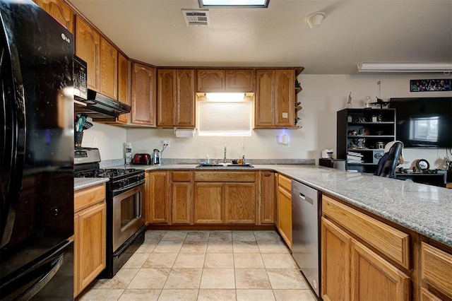 kitchen with black appliances, sink, light tile patterned floors, range hood, and light stone counters