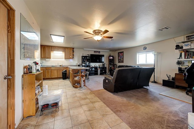 carpeted living room with ceiling fan and sink