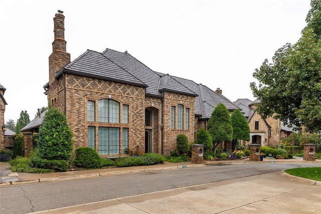 view of front of house with brick siding and a chimney