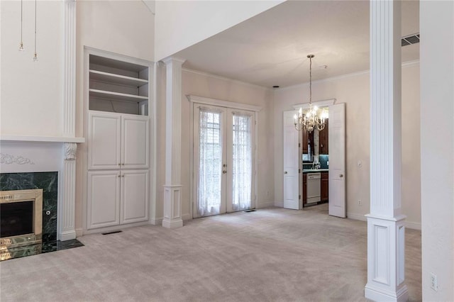 unfurnished dining area with a high end fireplace, french doors, light colored carpet, and decorative columns