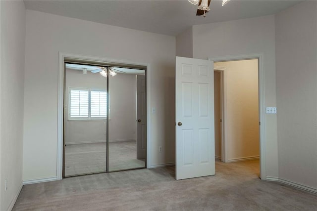 unfurnished bedroom with a closet, light carpet, and baseboards