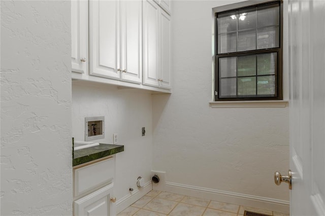 laundry room with cabinet space, baseboards, washer hookup, electric dryer hookup, and light tile patterned flooring