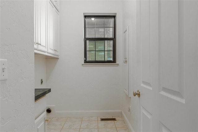 laundry area featuring cabinet space, baseboards, visible vents, and hookup for an electric dryer