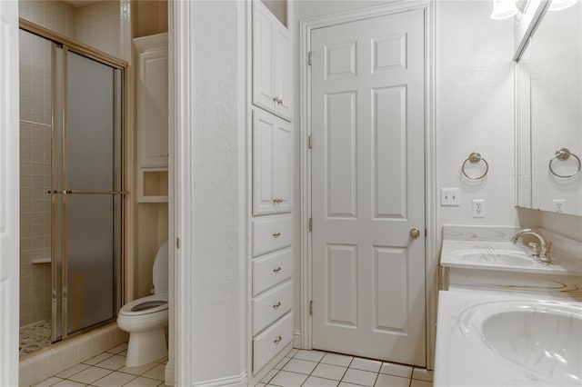 bathroom featuring double vanity, tile patterned flooring, a sink, and a shower stall