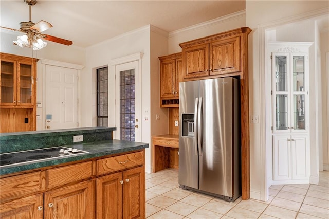 kitchen with light tile patterned floors, stovetop, brown cabinets, and stainless steel fridge with ice dispenser