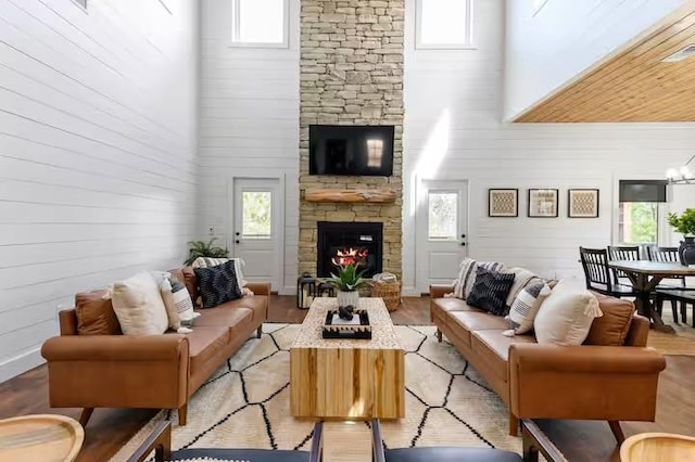 living room featuring plenty of natural light, a fireplace, and a high ceiling