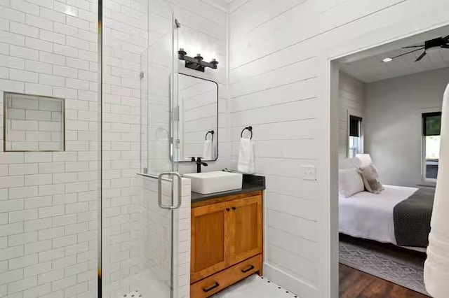 bathroom with vanity, hardwood / wood-style floors, and a shower with door