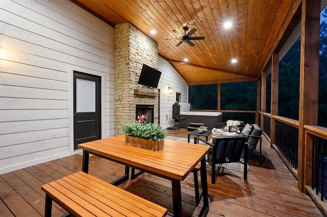 sunroom featuring ceiling fan, an outdoor stone fireplace, vaulted ceiling, and wooden ceiling