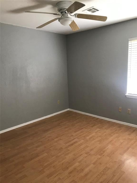 spare room with hardwood / wood-style flooring and ceiling fan