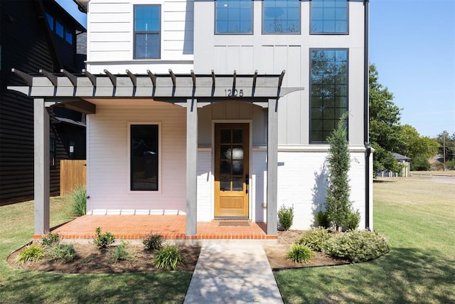 view of exterior entry with a lawn