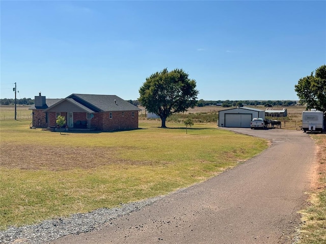 view of yard featuring a garage and an outbuilding