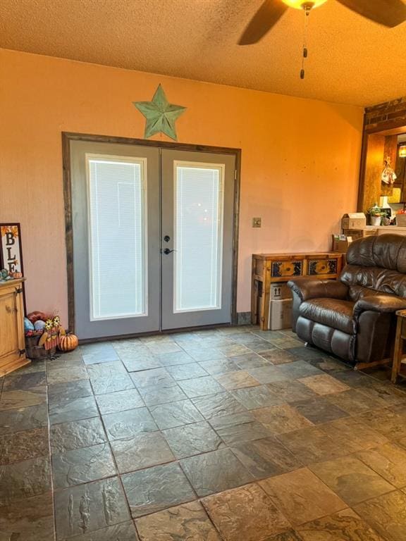 living room featuring french doors, a textured ceiling, and ceiling fan