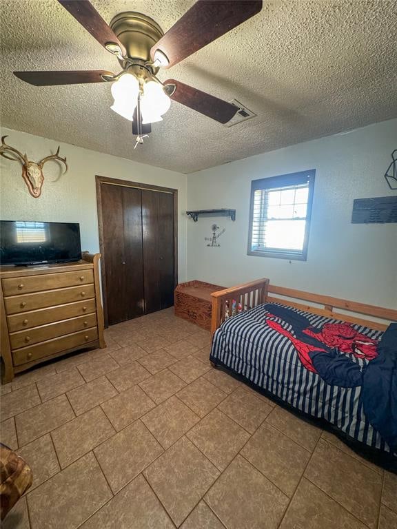 bedroom featuring ceiling fan, a textured ceiling, and a closet