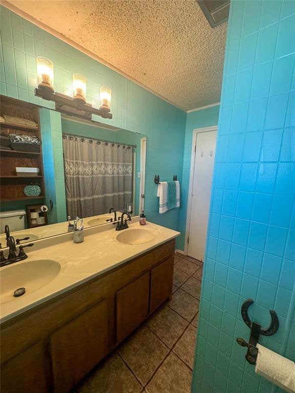 bathroom featuring tile patterned flooring, vanity, and a textured ceiling