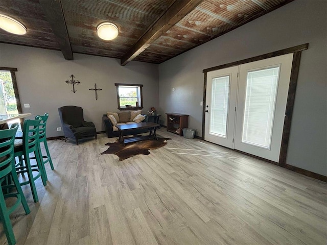 living room featuring lofted ceiling with beams, wooden ceiling, and light hardwood / wood-style floors