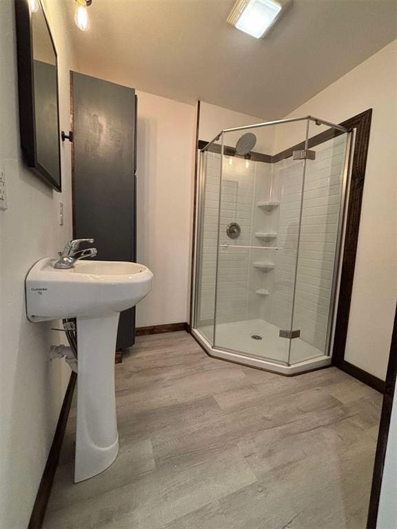 bathroom with hardwood / wood-style floors and a shower with door