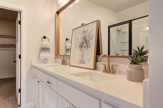 full bathroom with double vanity, a shower stall, and a sink