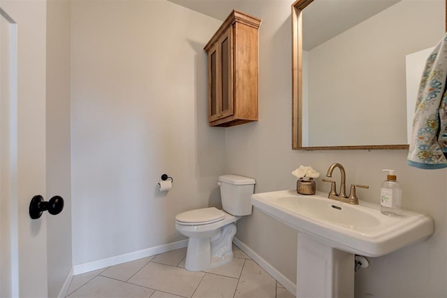 bathroom with a sink, tile patterned flooring, toilet, and baseboards