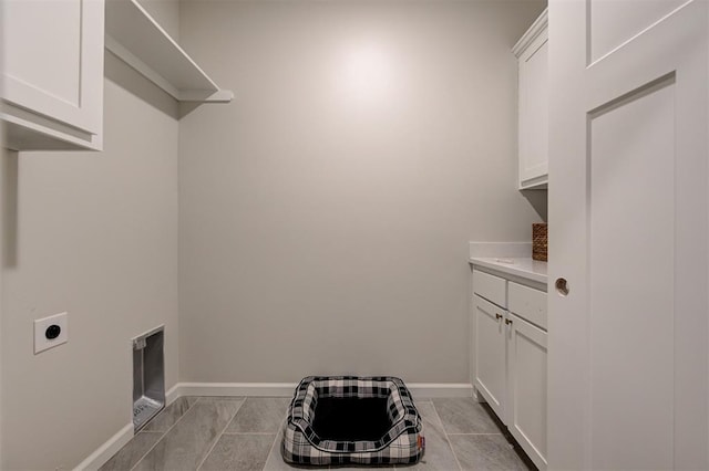 laundry room featuring cabinet space, baseboards, and hookup for an electric dryer