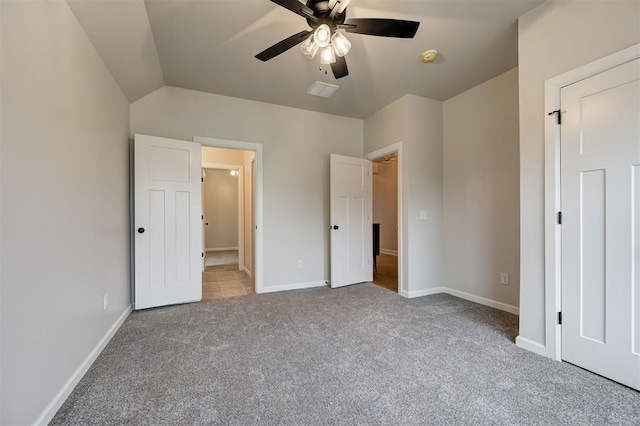 unfurnished bedroom with carpet, baseboards, and vaulted ceiling