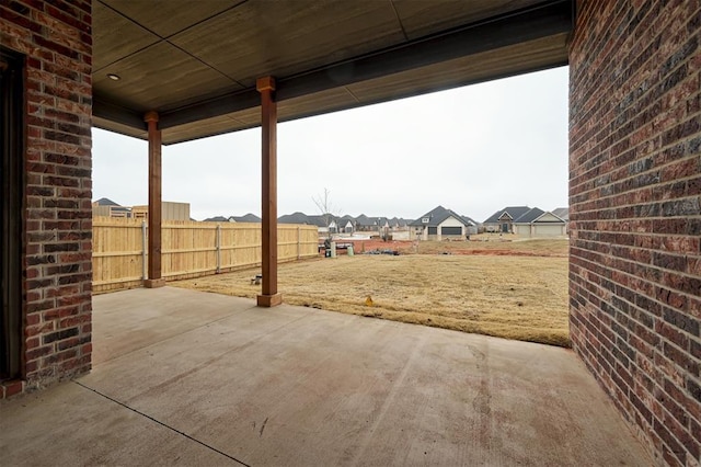 view of yard featuring a patio area, fence, and a residential view