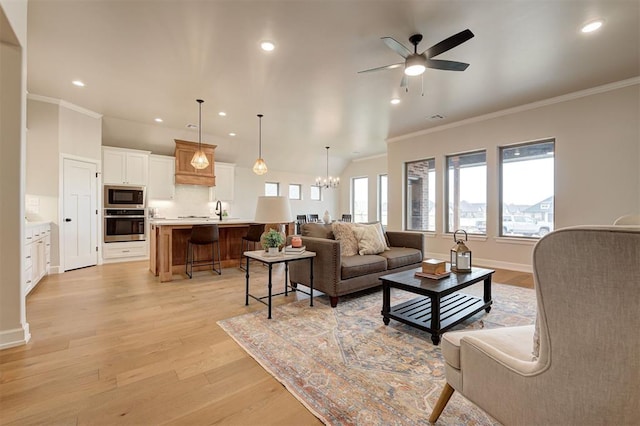 living room featuring ornamental molding, recessed lighting, light wood finished floors, and ceiling fan with notable chandelier