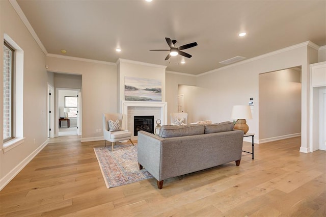 living room featuring light wood finished floors, a fireplace, baseboards, and recessed lighting