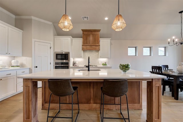 kitchen with light countertops, visible vents, a sink, built in microwave, and oven