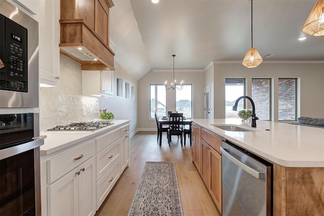 kitchen featuring light wood-style flooring, stainless steel appliances, a sink, and light countertops