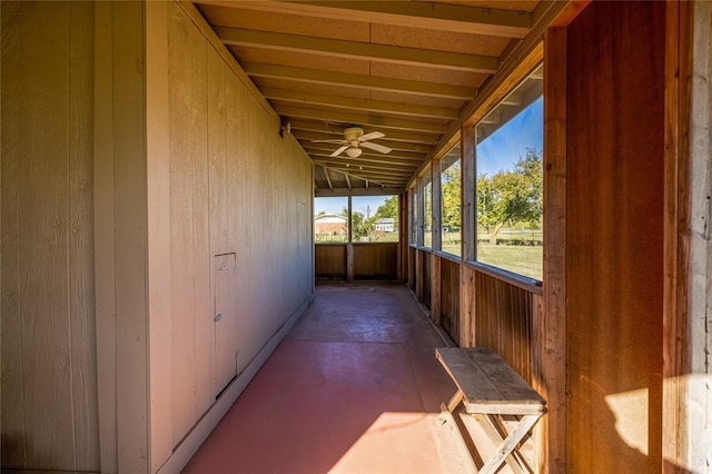 unfurnished sunroom featuring ceiling fan