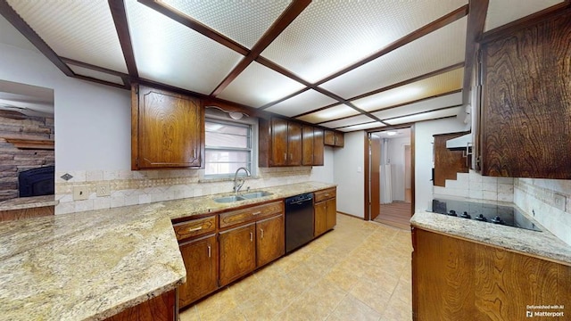 kitchen with light stone countertops, black appliances, range hood, decorative backsplash, and sink